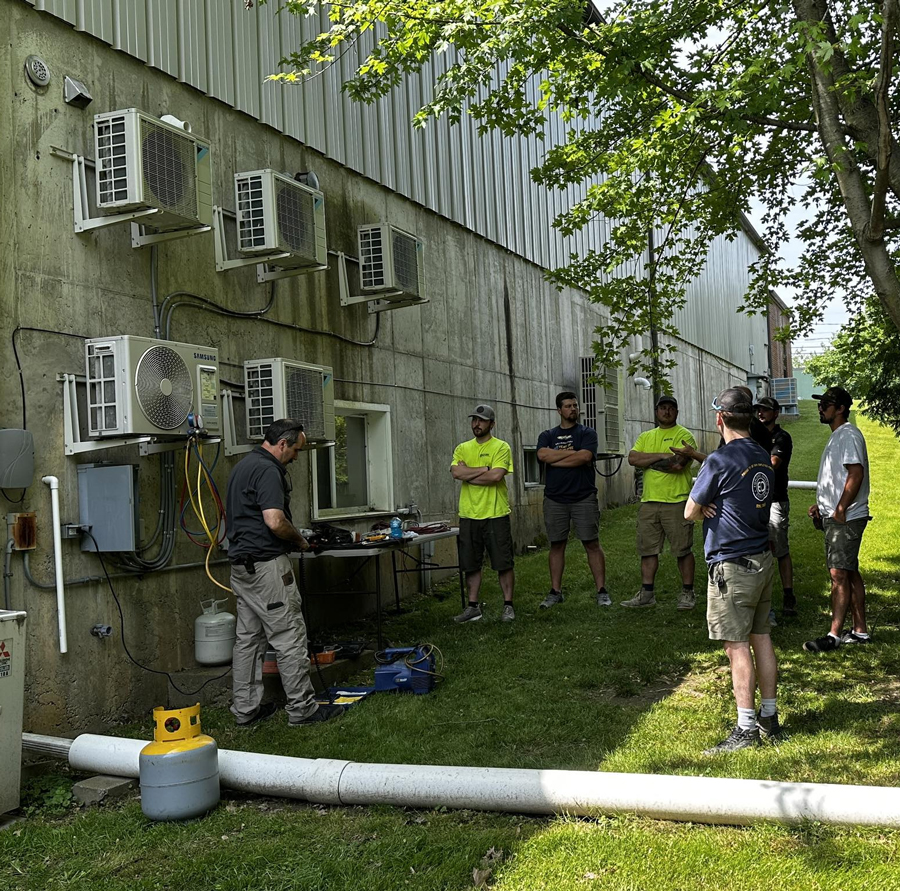 Group of men learning about in-house heat pump installation